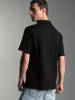Oversized Poloshirt ohne Knopfleiste in Waffeloptik Schwarz